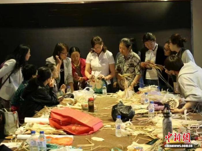 圖為曲秀傑(右六)正在講解草編技巧。曲秀傑供圖