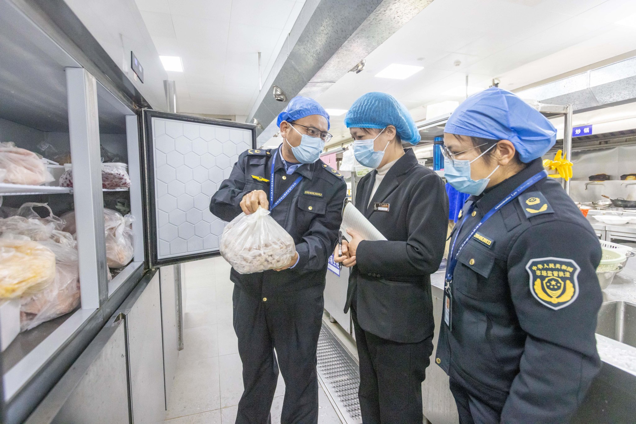 执法人员检查食堂后厨。蒙山县市场监管局供图