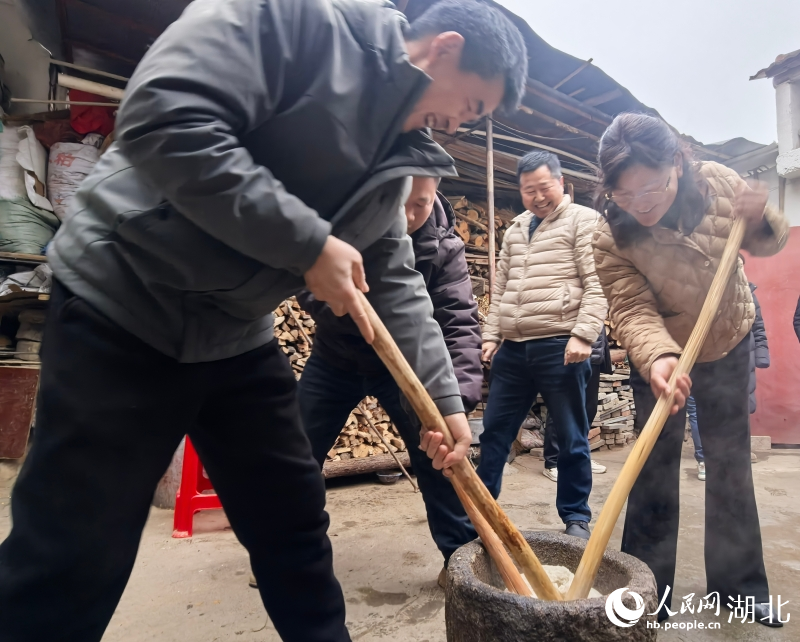 梁雲英（右一）正在和村民一起打糍粑。人民網記者 周雯攝