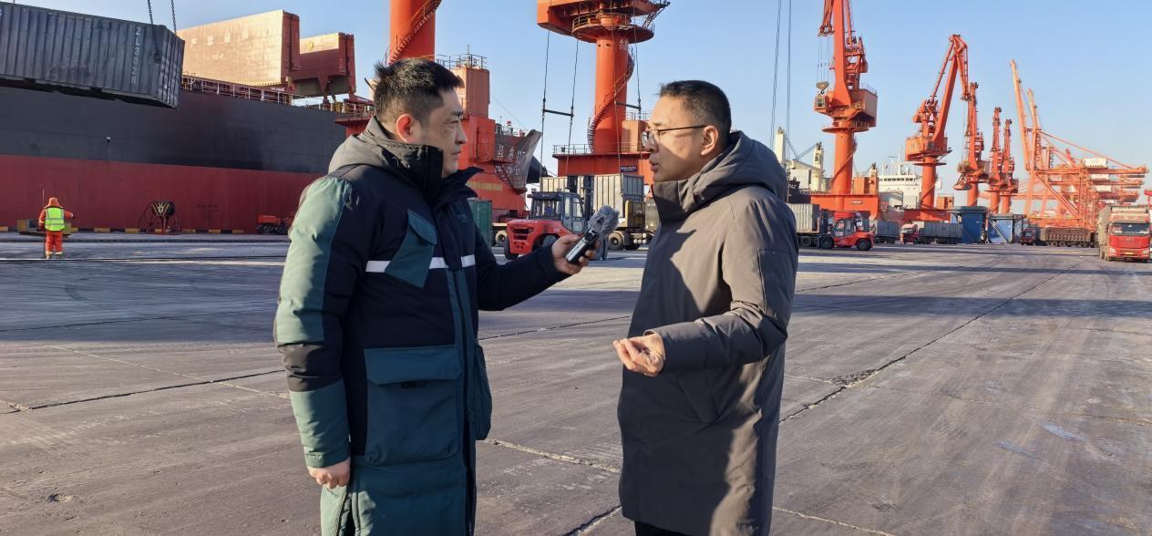 　　总台记者采访辽港控股（营口）有限公司生产部副部长柳伟杰（右）