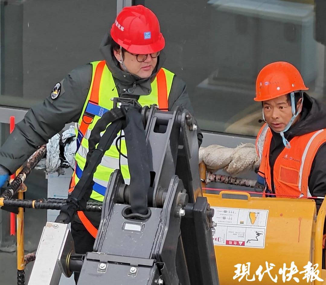 記者（左）與程正強乘坐曲臂車
