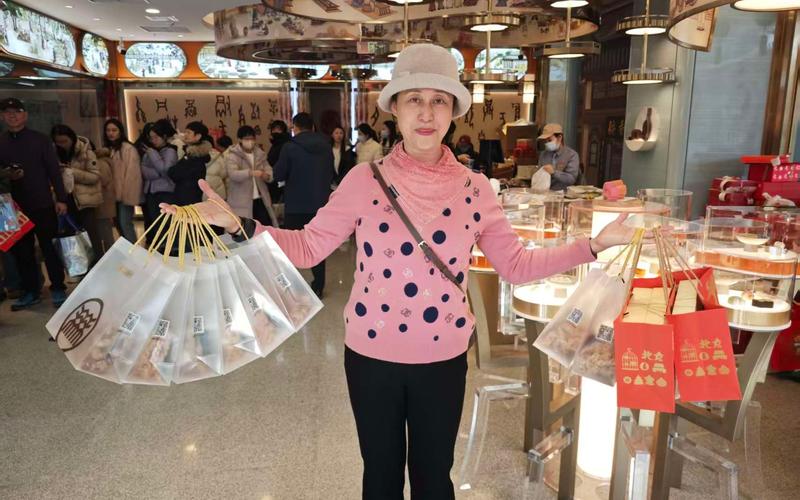 2月12日，北京稻香村零号店寻宝馆，游客郑女士购买了多份总书记同款年味小食。 新京报记者 郭铁 摄
