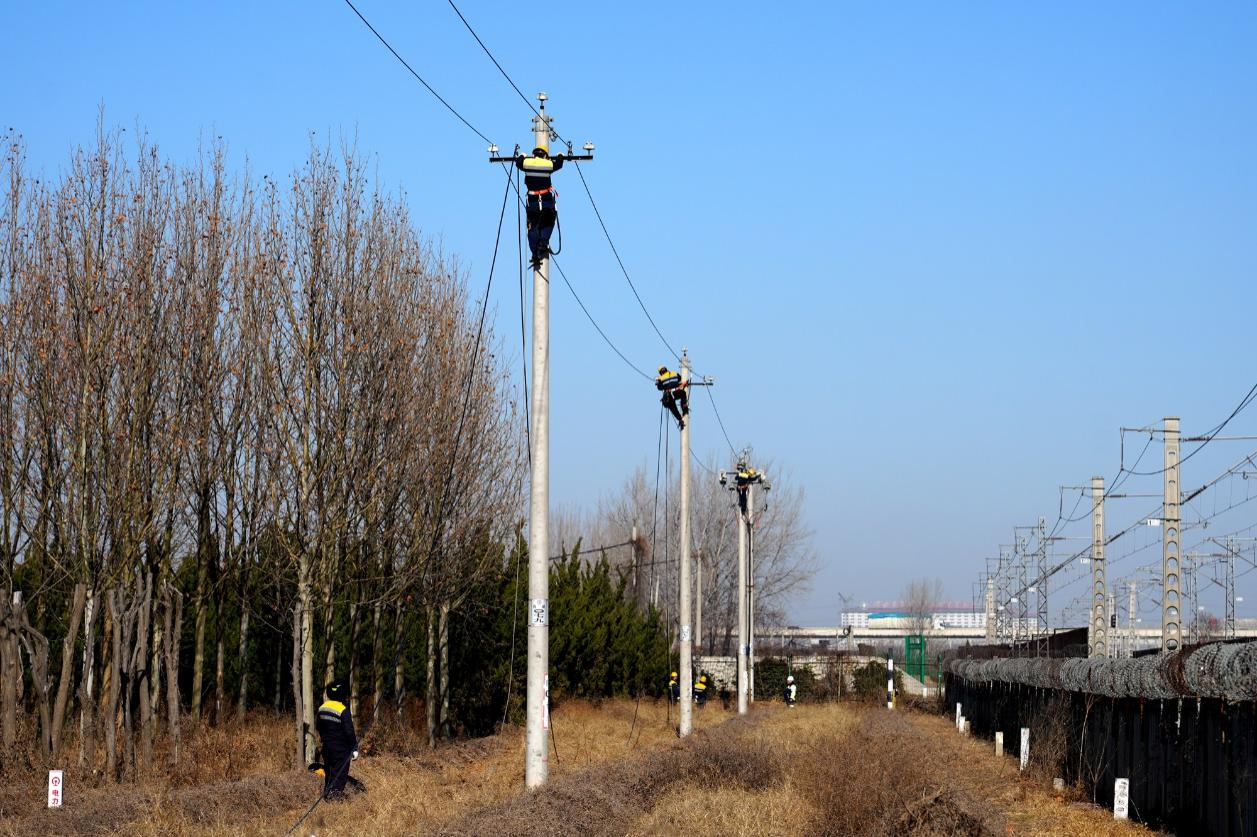 圖為鄭州供電段職工在8米多高的杆塔上開展電力線路更換作業。