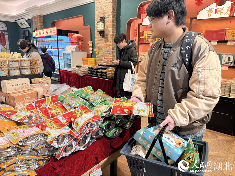 年青人選購過年「老三樣」。人民網記者 張雋攝