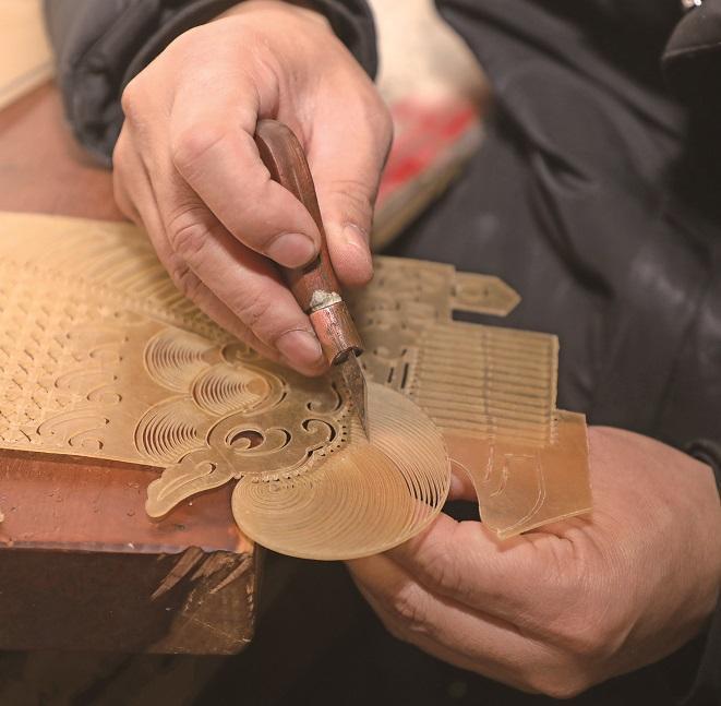 2月6日，张亚峰在雕刻皮影穆桂英。 通讯员 马辛摄