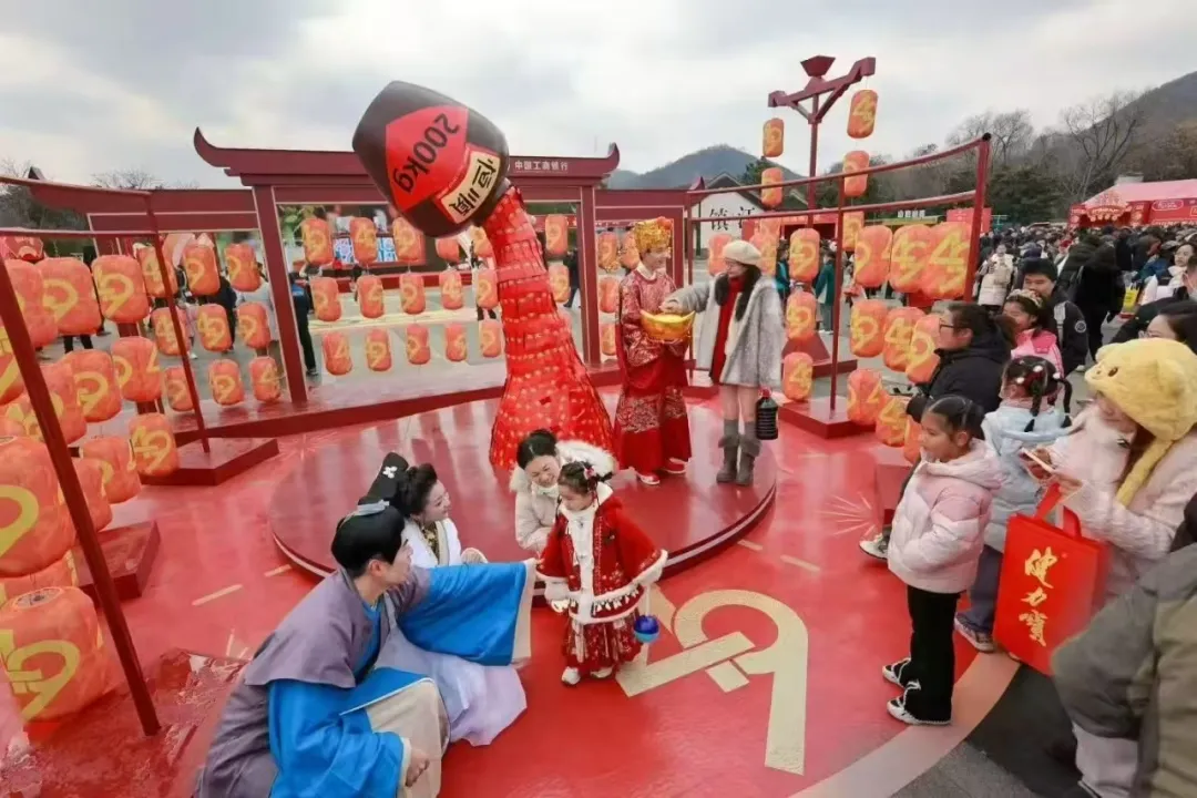 ​巨型醋坛装置亮相，游客与许仙、白娘子等古装人物互动打卡。李玥/摄