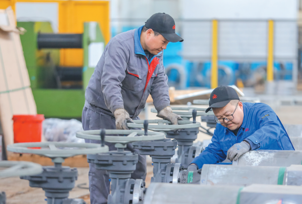 2月24日，在位于李沧区的青岛电站阀门有限公司，工人在生产车间内赶制阀门订单。张鹰 摄