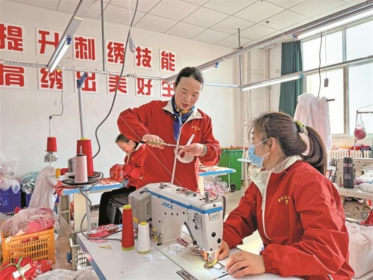 1月22日，在宝鸡市千阳县西秦刺绣文化产业园，王海燕（右二）在指导年轻绣娘（资料照片）。