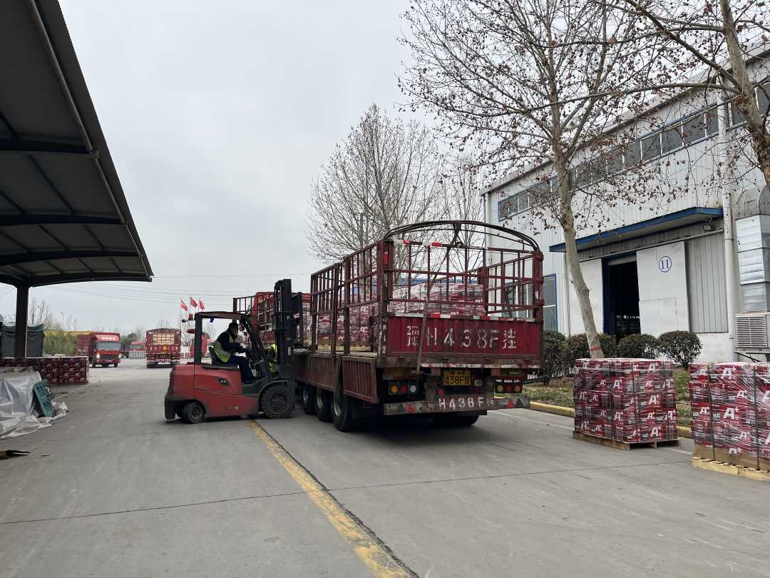 河南晶能电源有限公司仓库外，运输车辆正在等待装车发货。王菊芬摄