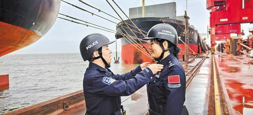 2月26日，在黄骅港完成执勤任务后，黄骅出入境边防检查站民警武帝豪（左）给妻子董秀丽整理衣服。 本报记者 戴绍志摄