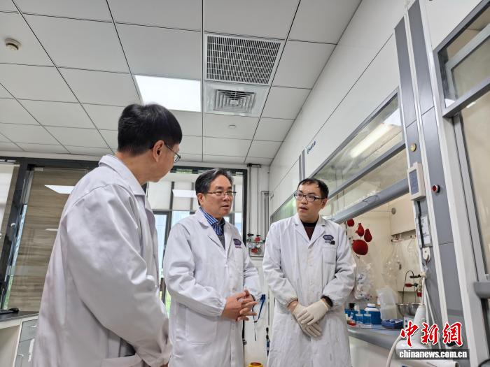 2月28日，丁列明(中)在实验室内与科研人员交流。张煜欢 摄