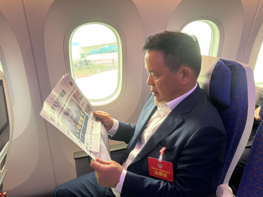 图为全国政协委员张春华阅读《21世纪经济报道》。郑康喜 摄