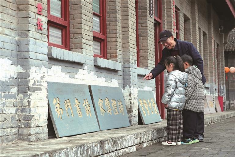 2月25日，党鉴泉在党家村家风园给孩子们讲解刻在青砖上的家训。 通讯员 彭一鹏 摄