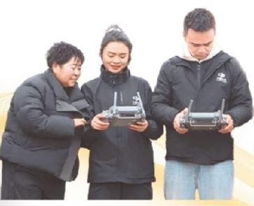管娇（中）向群众讲解无人机飞行数据。 曾田 摄