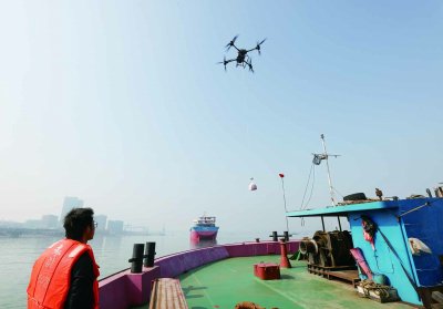 日前，南京上元门低空飞行基地附近江面，无人机悬停在货船上方，将外卖稳稳落在甲板上。南京日报/紫金山新闻记者 徐琦 摄