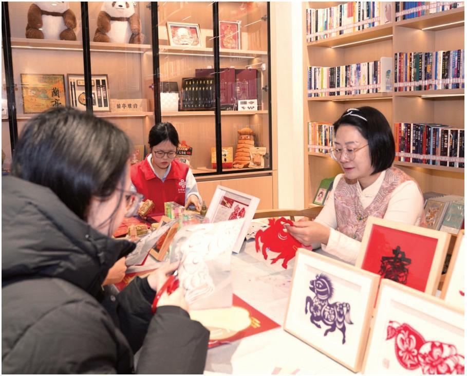 游客在陕西省图书馆“只此长安·秦韵书房”文旅融合服务体验空间体验剪纸（资料照片）。 记者 柏桦摄