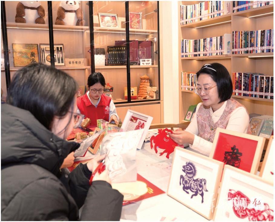 游客在陕西省图书馆“只此长安·秦韵书房”文旅融合服务体验空间体验剪纸（资料照片）。 群众新闻记者 柏桦摄