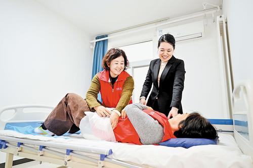 2月28日，“河北福嫂”李爱凤（左）在北京阳光北亚家政服务有限公司参加养老护理技能培训。 本报记者 张昊摄