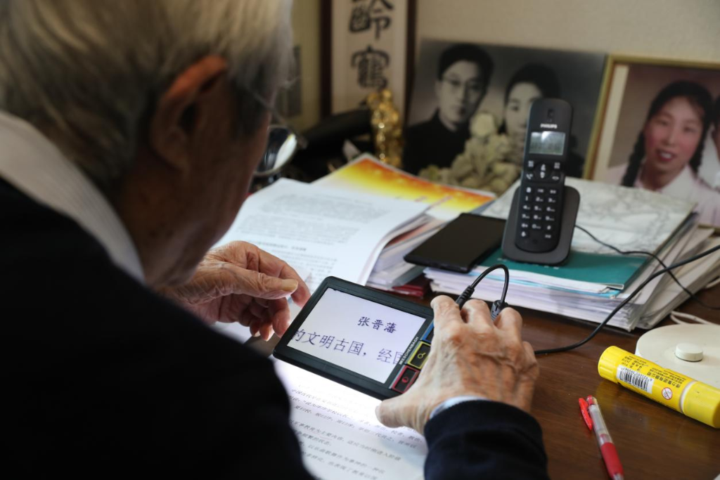 2025年3月，張晉藩先生在公開課上課前用放大鏡備課。新華社發