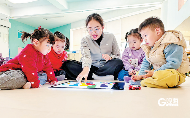 青岛恒星科技学院托育中心的老师与孩子们互动。