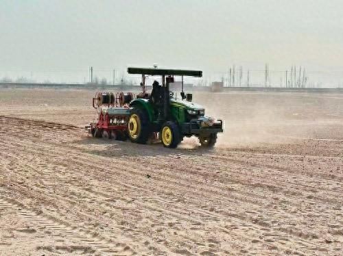 在宁夏农垦黄羊滩农场，智能播种机正在播种。 受访者供图