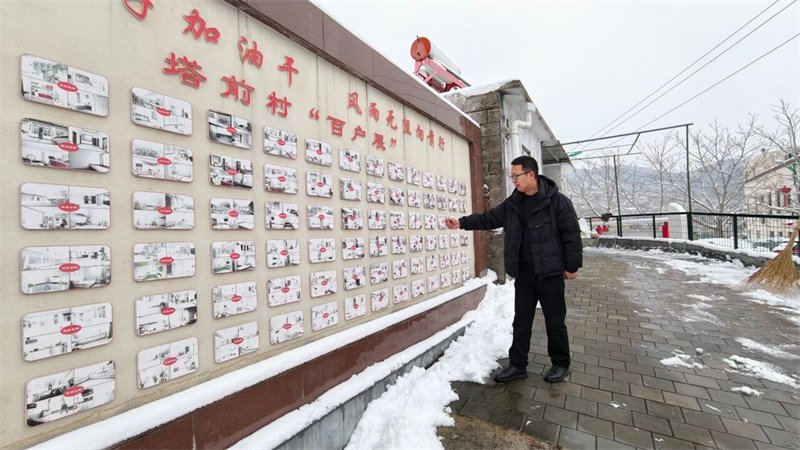 3月5日，兴隆县塔前村，村党支部书记王大龙在介绍村里的美丽庭院照片墙。 河北日报记者 王思达摄