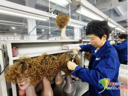 完成车间内工人梳理假发。中国青年网见习记者王煜鑫 摄