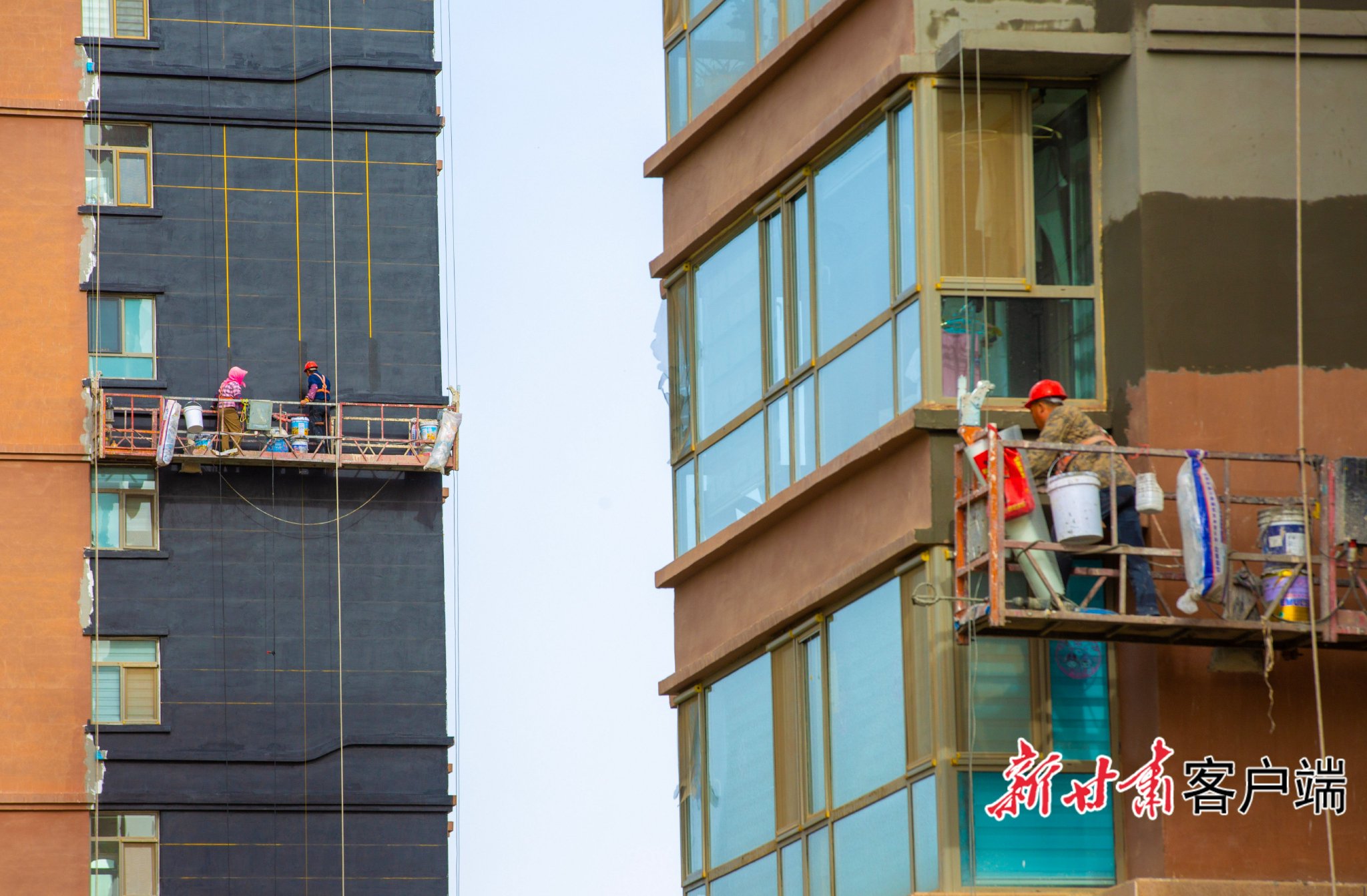 在张掖市甘州区老旧小区改造现场，工人正在进行外墙装修粉刷作业。新甘肃·甘肃日报通讯员 杨潇