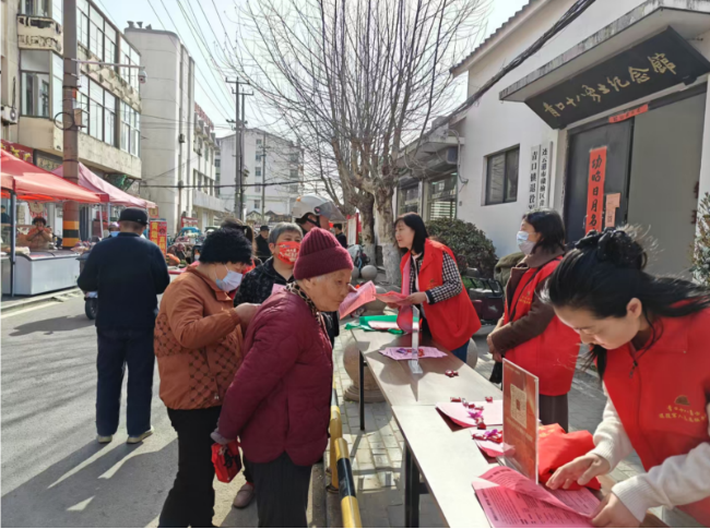 图：工作人员向老人宣传“安康关爱行动”。