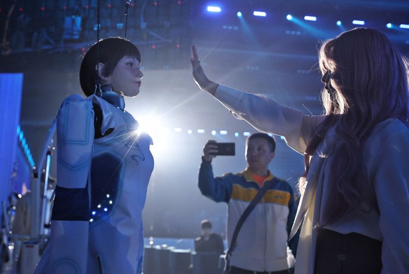 工作人员与人形机器人互动。