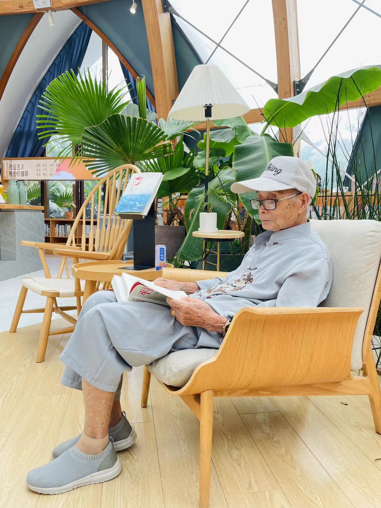 ▲ 一位百歲老人正在蓮花書屋內專心閱讀。