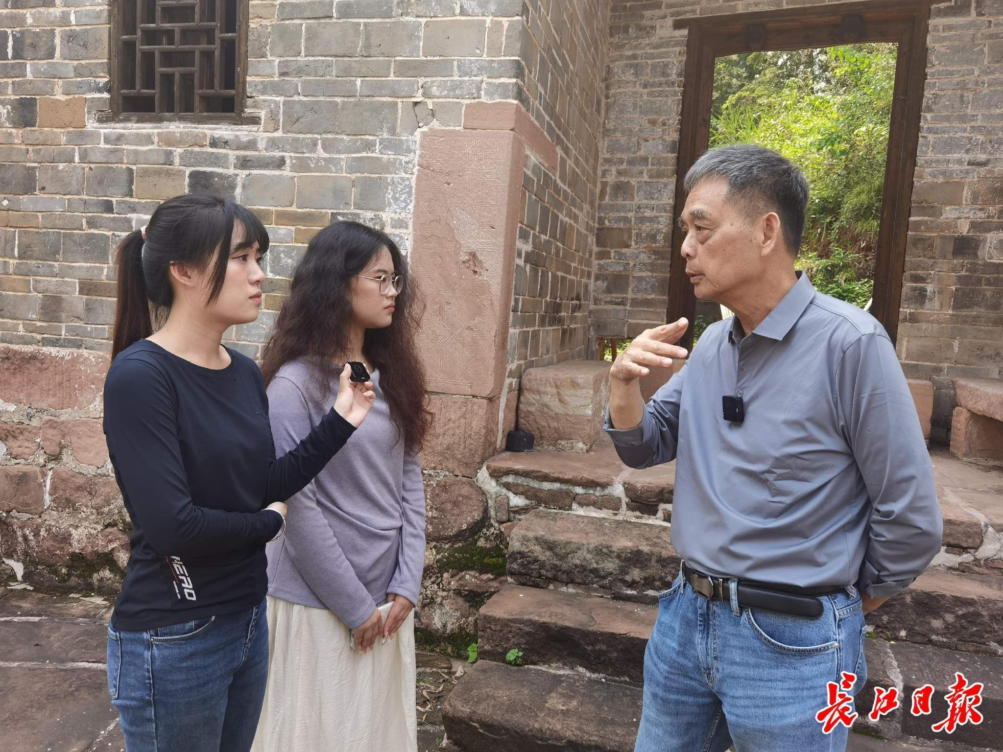 在中山大學坪石舊址，吳傑明（右一）向兩名台灣女生講述父親在坪石的工作經歷。記者楊佳峰 攝