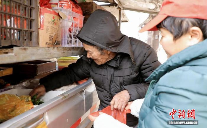 村民在流動供銷服務車前選購生鮮蔬菜。唐濤華 攝