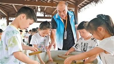 章仕康在帶領孩子們體驗連四紙製作。丁銘華攝