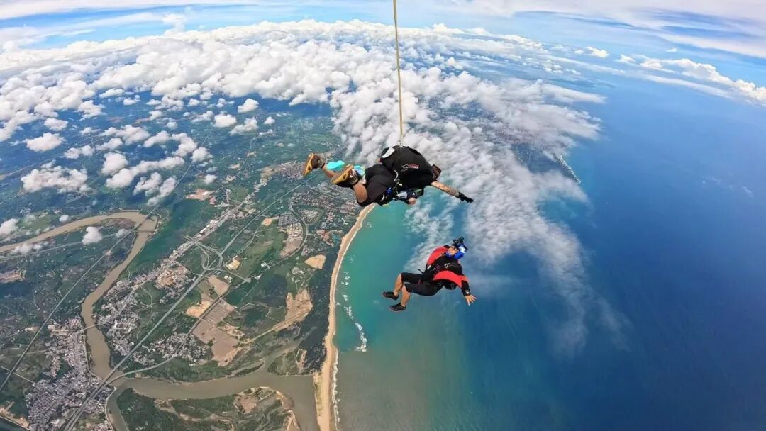 游客在海南三亚体验高空跳伞。