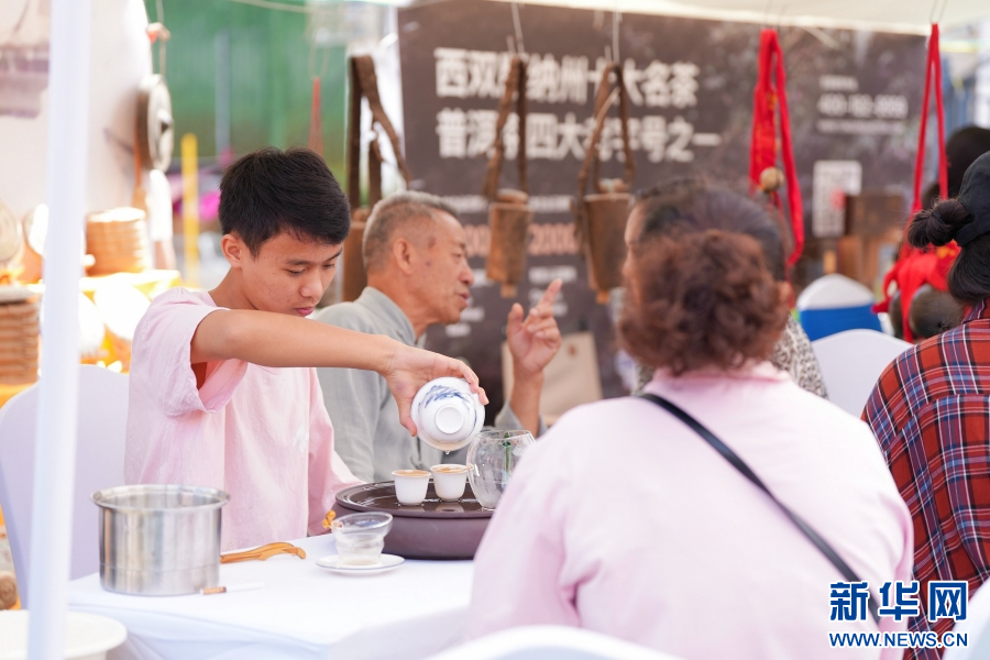 市民遊客在活動現場品茶（5月16日攝）。新華網發（猛臘縣融媒體中心 供圖）