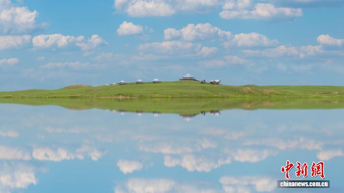 圖為藍天、白雲、綠草相映成趣，宛若一幅油畫。田昊霖 攝