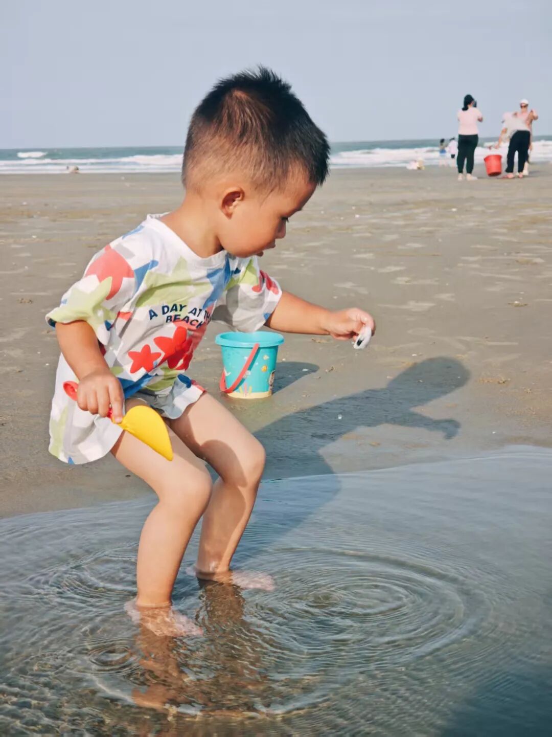 小朋友踏浪赶海。