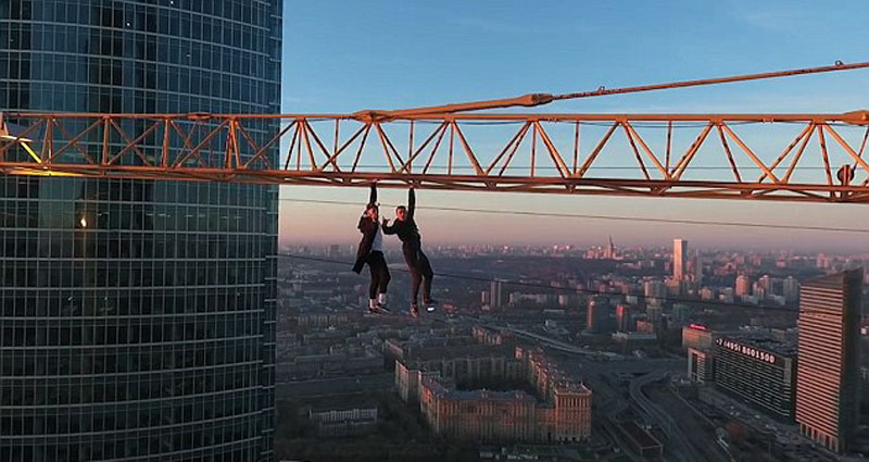 俄两男子百米高空塔吊上大耍特技，被批愚蠢。