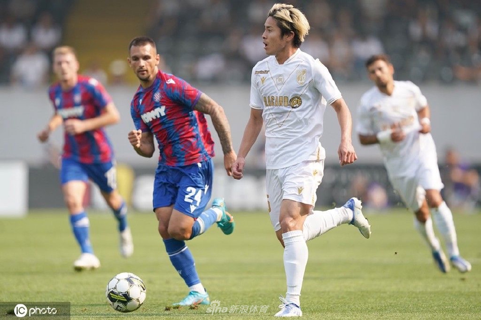 看台上一位身穿吉马良斯球衣的小球迷，手扶栏杆眼神专注地凝望着赛场