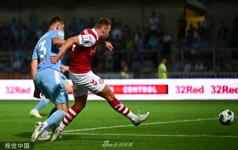 夜幕降临，球场灯光如昼，布里斯托尔城球员带球突破，身影在草皮上拉出长长的影子。