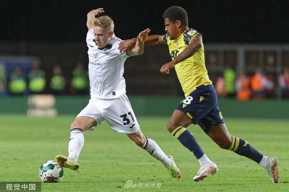 牛津联球员亚历克斯·罗德里格斯进球后张开双臂滑跪庆祝，身后是欢呼的队友