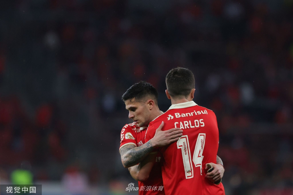 弗鲁米嫩塞球员带球突破，遭遇巴西国际队两名防守球员的凶狠夹击，三人腿部交错，争夺激烈。