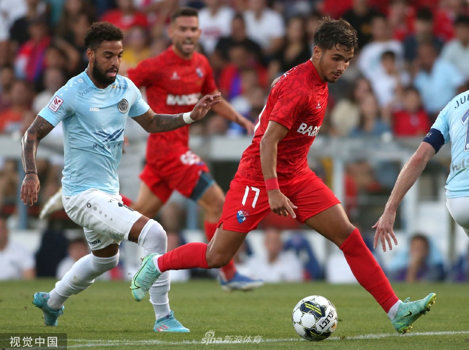 看台上红衣主队球迷掀起壮阔的人浪，如同燃烧的火焰席卷整个看台，他们的热情是球队最坚实的第十二人。