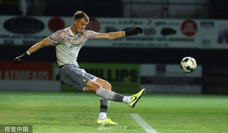 纽波特郡球员在攻入关键进球后张开双臂奔向角旗区疯狂庆祝，身后是沮丧的卢顿队防守球员。