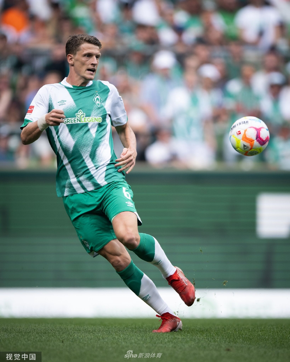 不莱梅老教练在场边紧握双拳，神情专注而紧张，目光如炬地注视着场上瞬息万变的局势。