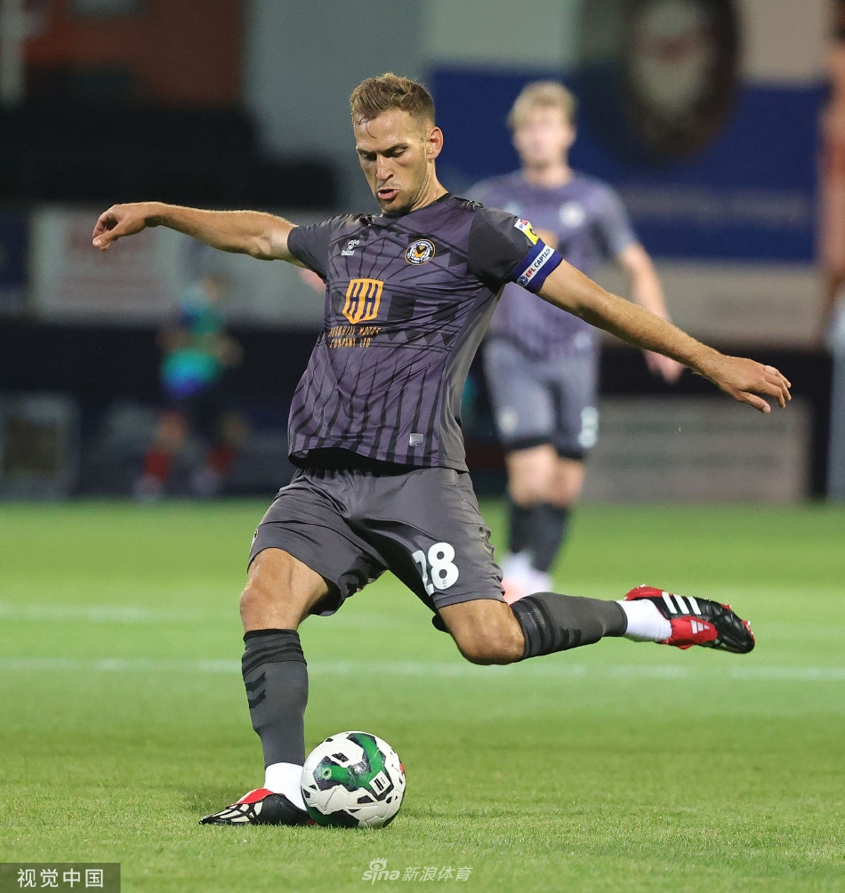 一名纽波特郡球员在中场与卢顿球员激烈拼抢，两人身体对抗强劲，足球在脚下若隐若现，争夺异常激烈。