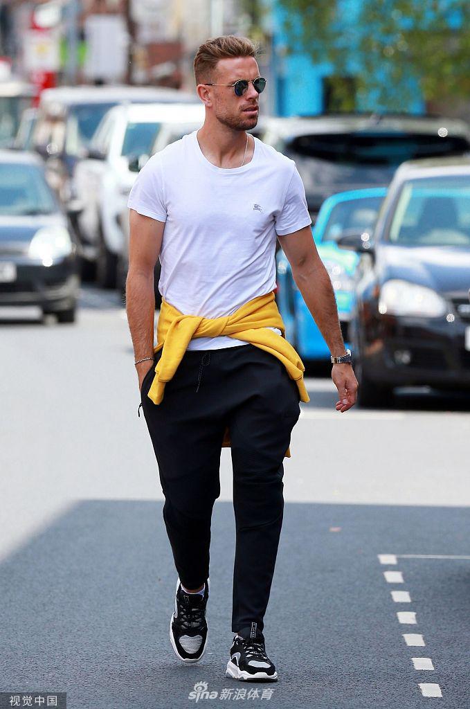 走在熟悉的街道上，亨德森神情自若，享受着难得的闲暇时光，背景里欢呼的利物浦市民与他共同构成了夺冠后最美的城市风景。