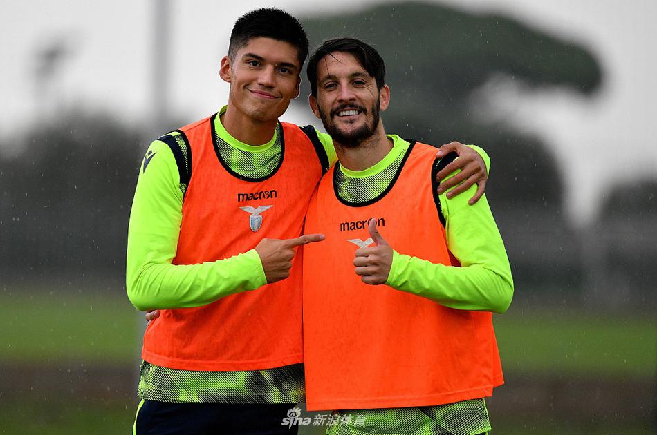 在罗马福尔梅洛训练基地的夕阳余晖下，拉齐奥球员们正进行高强度的分组对抗，一名中场球员奋力跃起争顶，草屑在空中飞扬，定格了力量与专注的瞬间。