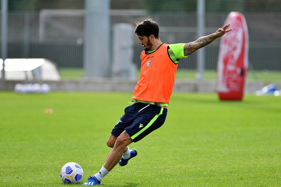 主教练小因扎吉双手插兜，目光如炬地注视着训练场上的每一个细节，他的身影在午后阳光的拉长下，仿佛勾勒出一位球场雕塑家的专注与思考。